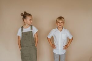 Duas crianças em roupas casuais e aventais. Moda infantil para meninos e meninas com conforto e durabilidade.